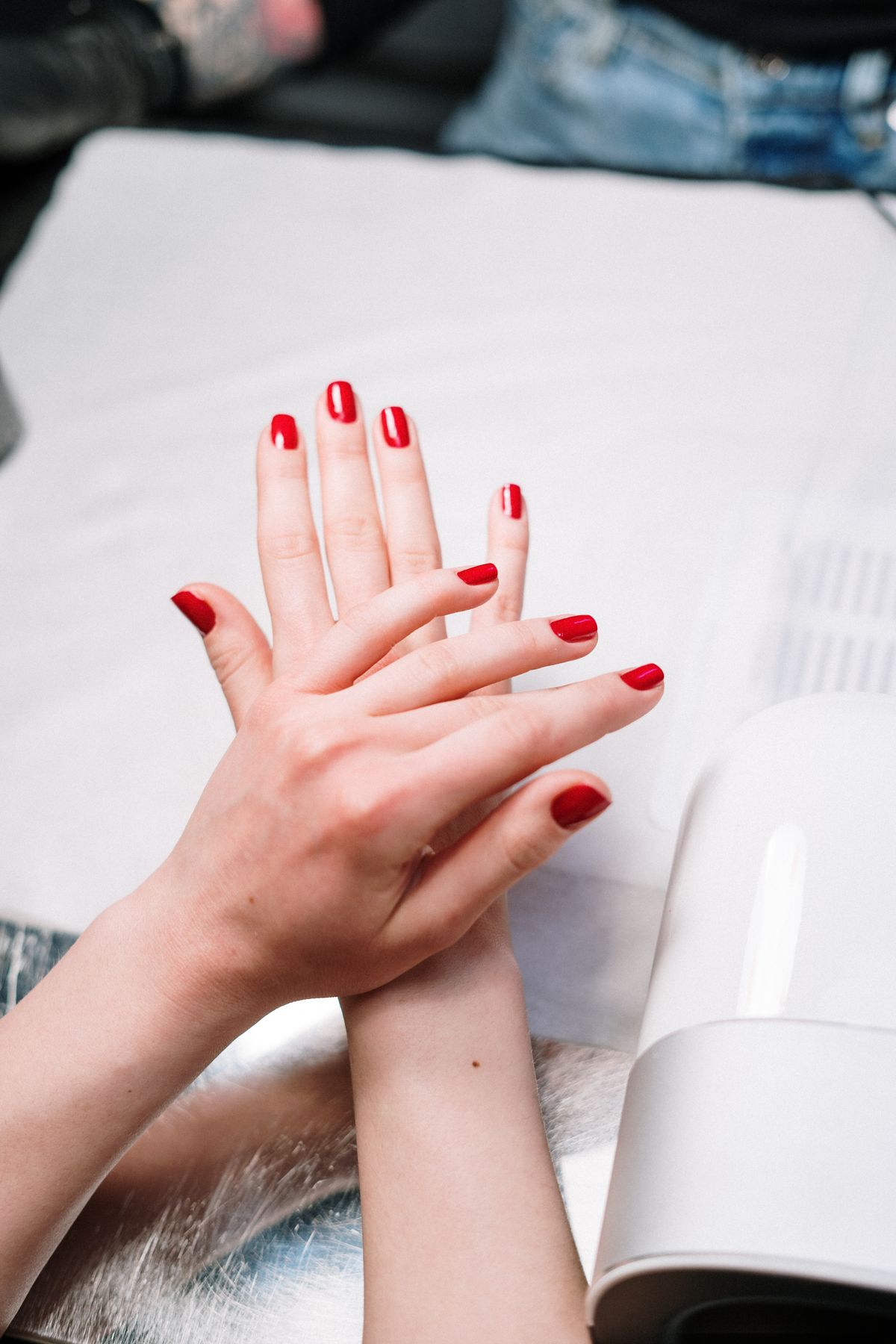 Gel manicure being finished under a nail lamp